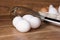 White and beige eggs with a blender on a wooden board