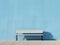 a white bench sitting against a blue wall