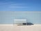 a white bench sitting in front of a blue tiled wall