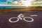 White bicycle road sign on asphalt lane