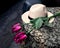 White biege woman hat and rose flower on the top of table with tablecloth. Concept of waiting for romantic true love and dating