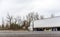 White big rig semi truck with dry van semi trailer moving on the road with winter trees on the background