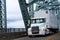 White Big rig semi truck and reefer on farm bridge