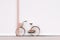 White bike parked against wall with basket on the back of it. Generative AI