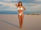 White bikini mockup on a beautiful girl posing on the beach, swimwear, for design, print, pattern