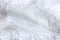 White bird feather lies on towel closeup