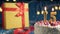 White birthday cake number 15 golden candles burning by lighter, blue background with lights and gift yellow box tied up