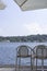 White bistro furniture on the shores of Lake Garda in Salo, Italy. The view invites you to relax in the shade. Drink an espresso