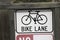 White and black bike lane sign.