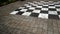 White and black chessboard painted on a stone floor with a geometric design