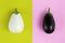 White and black eggplants isolated on green and pink background