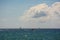 White and black sailboat in the Mediterranean sea, beautiful cumulus clouds
