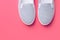 White and black striped canvas shoes on fuchsia pink background. Classic casual footwear youth teenager urban fashion