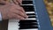 White and black synthesizer keys. The pianist`s hand plays on the electronic piano