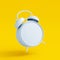 White blank alarm clock on yellow background. No time concept