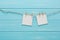 White blank cards on rope, blue wooden background