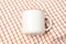 A white blank enamel mug on the top of a hand cloth with clean and simple looks