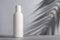 White blank packaging cosmetic bottle with shadow of palm leaves