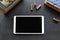 White blank tablet as space for your text and letter rubber stamps on a black tabletop