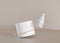 White and blank, unbranded cosmetic cream jar and dropper with flying golden ring on beige background. Skin care product