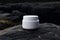 White and blank, unbranded cosmetic cream jar standing outdoors, on the rocks. Skin care product presentation. Skincare