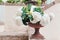 White blooming hydrangea in a marble flowerpot adorns the railing of the stairs in a country house, selective focus