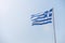 White blue Greece flag on white pylon with blue sky with cloud