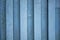 A white blue metal wall. vertical lines. paint and rust stains