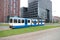 White and blue streetcar in the streets of Amsterdam in the Zuidas district
