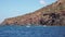 White boat in distance moored in Mediterranean sea at Lipari Island. Blue sky with white clouds. Summer sunny day