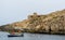 White boat moored in Wied iÅ¼-Å»urrieq inlet and WW2 stone military pillbox