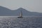 White boat sailing close to the coast blue aegean sea in Greece