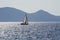 White boat sailing close to the coast blue aegean sea in Greece