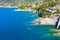 White boat sailing near rocky coast in Camogli, Italy. Aerial view on Adriatic seaside, liguria.