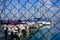 White boats  in a small harbour, behind a fence