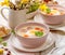 White borscht, polish Easter soup with the addition of white sausage and a hard boiled egg in a ceramic bowl.