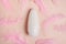 White bottle with Body antiperspirant deodorant roll-on on pink background with feathers
