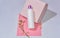 White bottle for shampoo and cosmetics with place to write and logos on pink background with plaster and flower.