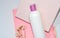 White bottle for shampoo and cosmetics with place to write and logos on pink background with plaster and flower.