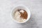 White bowl with flour, cocoa and baking powder on gray textured background. Cooking chocolate cake. Healthy homemade food concept