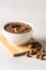 White Bowl with Homemade Tasty Chocolate Cream on Wooden Tray Raw Hazelnuts Gray Background Vertical