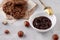 White bowl with natural hazelnut oil, golden spoon, healthy cookies, hazelnuts on a light background. Vegetarian traditional