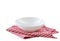 White bowl on red checkered cloth folded towel isolated