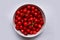 A white bowl with ripe and washed cherries. Top view.