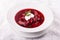 White bowl of traditional Ukranian soup borsch or vegetable beetroot soup with sour cream.