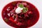 White bowl of traditional Ukranian soup borsch or vegetable beetroot soup with sour cream.