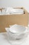 White bowl on a white background with cardboard box in the package. Concept relocation, new dishes