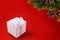 White box with gift tied with silk ribbon with bow and sprig of Christmas tree