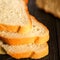 White bread sliced on a dark wooden table. Selctive focus. Blurred background.