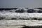 White breakwater foam hit on lonely black lava sand beach at Pacific coastline - Cobquecura Piedra De La Loberia, Chile